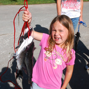 Grace Porter struggles to hold up her stringer of fish. (photo by Chris Erwin)