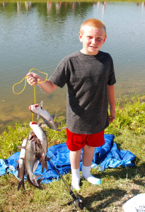 Tyler Smith showing off his stringer of catfish. (photo by Chris Erwin)