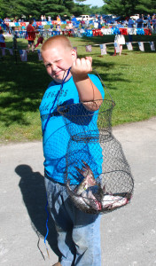 Warren Curtis proudly displays the basket of fish he caught at the Kids Fishing Derby. (Photo by Chris Erwin)