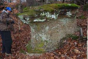 Author Chris Erwin standing by one of the sandstone formations that holds many types of collectable rocks and minerals, which are washing out of the sandstone. (Photo by Linda Erwin)