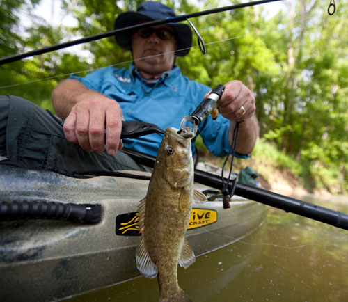 Fish grippers, such as this one used to remove a lure from the mouth of a smallmouth bass prior to release back into Jefferson County’s Floyds Fork Creek, are invaluable tools for anglers who want to release their catch in summer. Proper fish handling techniques help fish thrive after release during the hot months.  